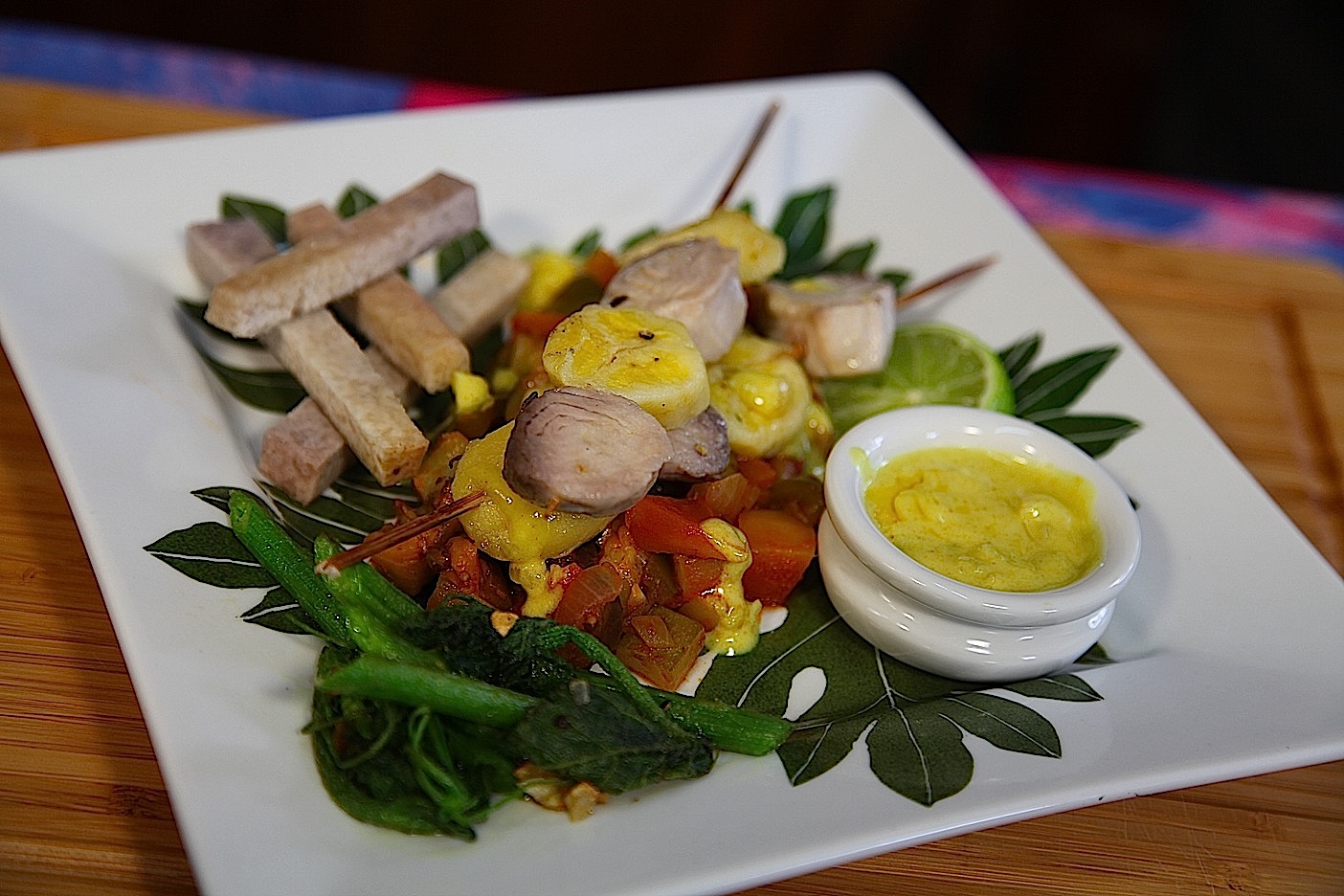 Brochettes de mahi mahi et bananes couchées sur un lit de ratatouille au basilic sauvage et lait de coco