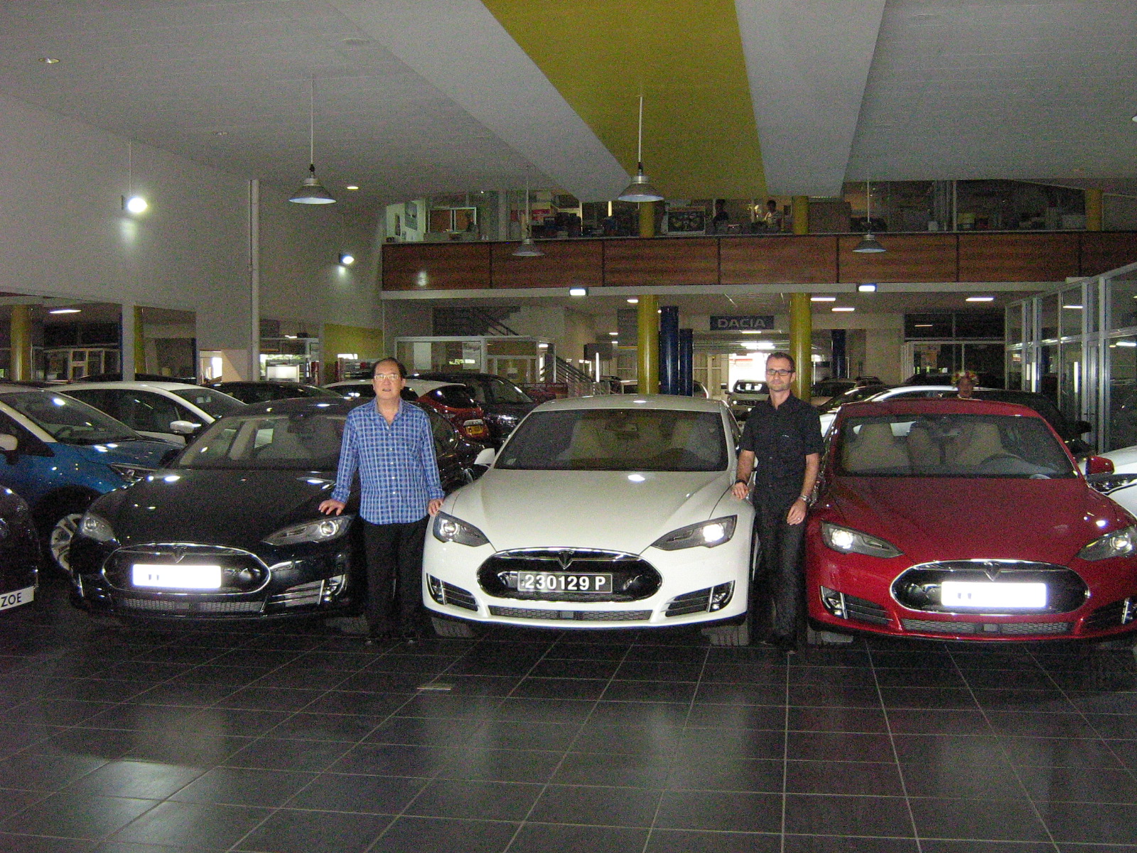 Paul Yeou Chichong et Gilles Bonvarlet devant trois Tesla aux couleurs du drapeau tricolore