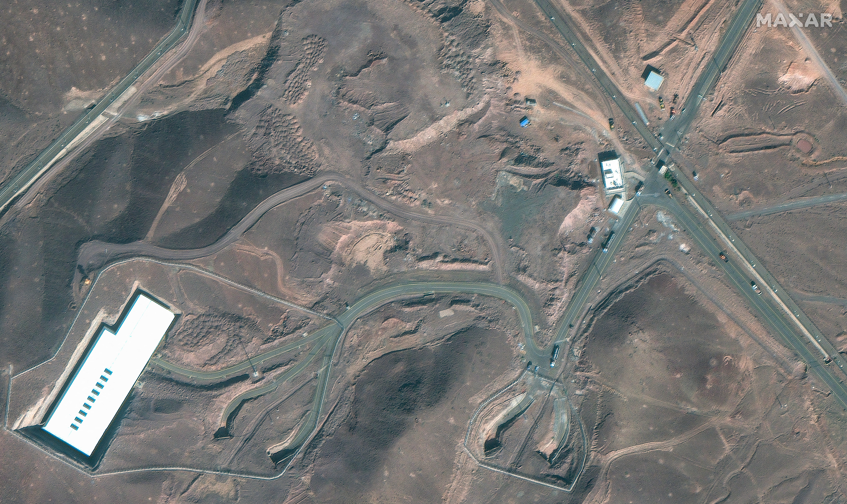 Cette image satellite diffusée avec l'autorisation de Maxar Technologies montre des camions de marchandises positionnés près d'une entrée souterraine de l'usine d'enrichissement de combustible de Fordo (FFEP), à Fordo, en Iran.