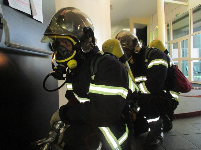 Des pompiers venus de tout Tahiti sont arrivés pour prêter main forte à leurs confrères de Paea. Une lance à incendie a été déployée. Afin de pénétrer en toute sécurité dans la salle Manu iti, les pompiers, la lance à incendie sous le bras, portent un casque et un appareil respiratoire isolant pour ne pas inhaler de fumées toxiques.