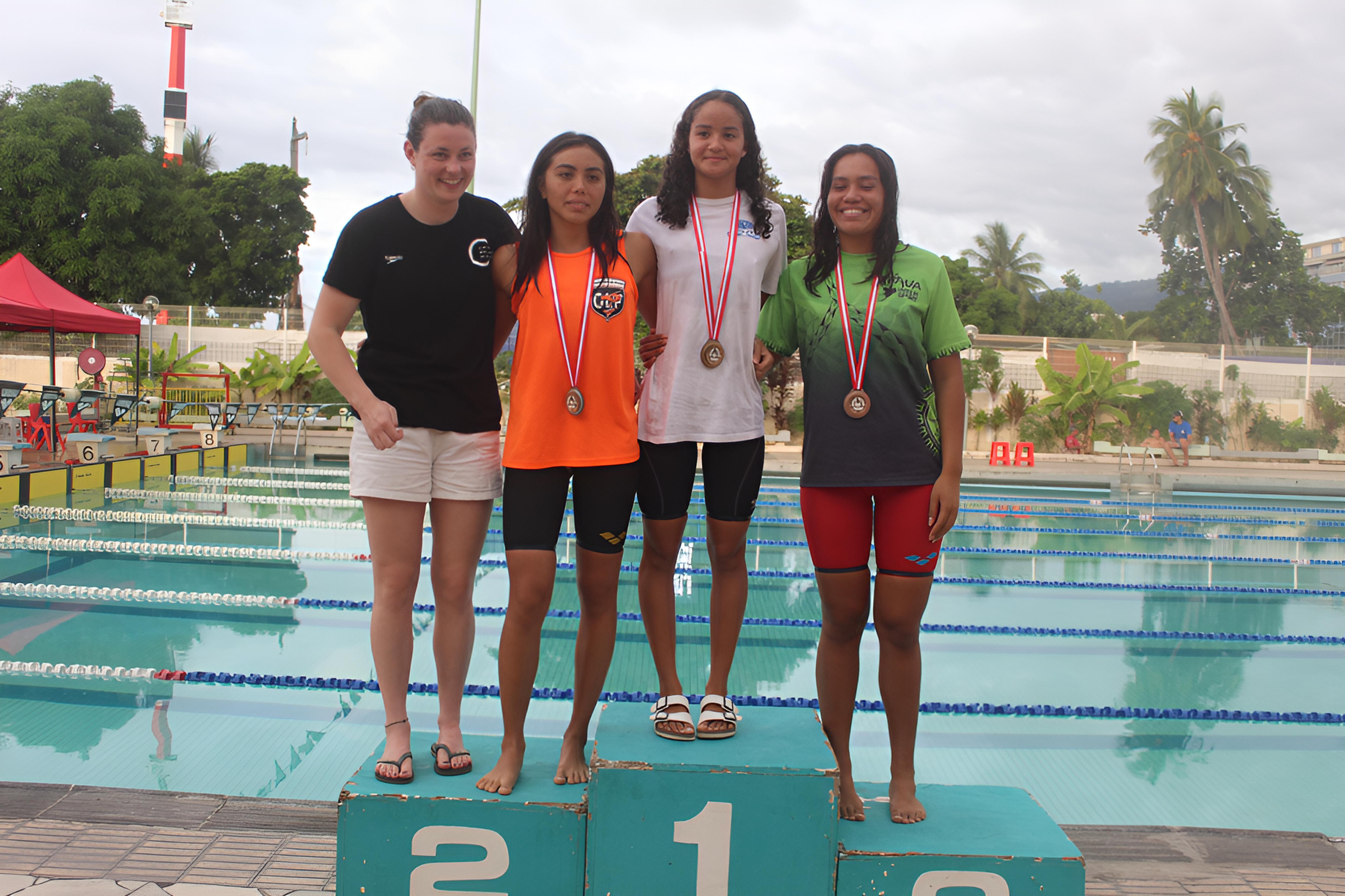 Déotille Videau (en blanc) a marqué les Championnats de Polynésie 2026 de natation de son empreinte. Elle est entourée sur le podium du 50 m dos par Éric Quennelec, Hawaiki Moro et Toreana Narii.
