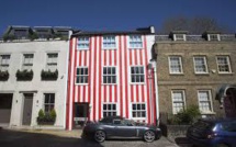 GB: Pour se venger de ses voisins, elle couvre sa maison de rayures rouges