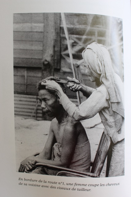 Une femme coupe les cheveux de sa voisine avec des ciseaux de tailleurs.