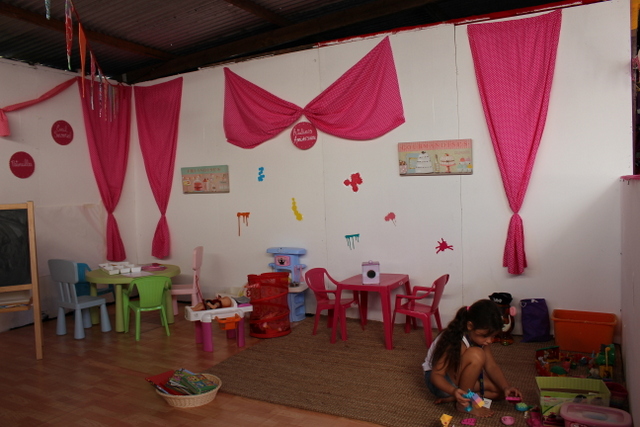 Les p'tits ateliers montent un stand aux couleurs qui font son identité (imprimé rose ou violet à pois blancs, nœuds, mobilier coloré, coin jeux, matériel de bricolage, etc.).